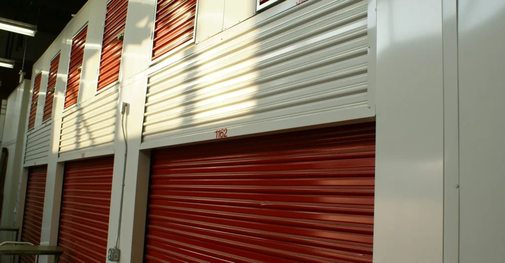 Row of red roll-up doors of indoor self-storage units